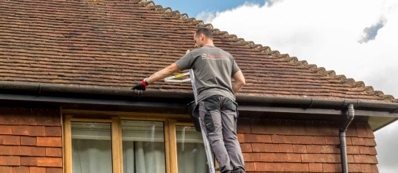 Gutter cleaning a residential property in Leigh